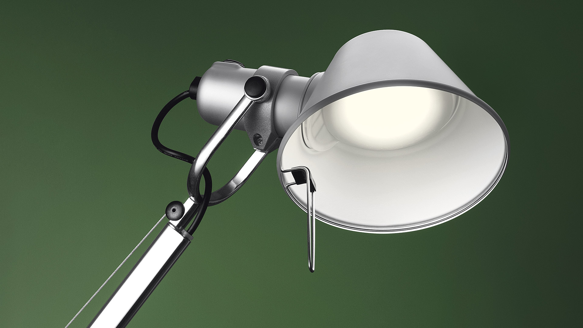 Lampada iconica Tolomeo di Artemide fotografat ain primo piano con sfondo verde